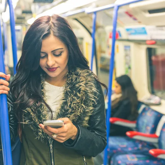 Woman on a train looking at a phone